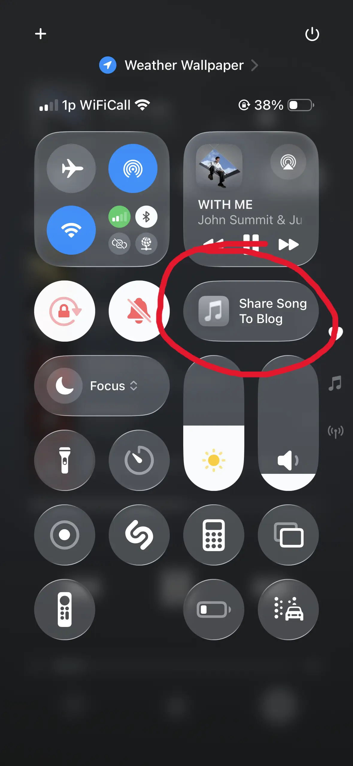 a screenshot of a an iphone control centre. underneath the media controls is a button which says 'share song to blog'. the button is circled in red.